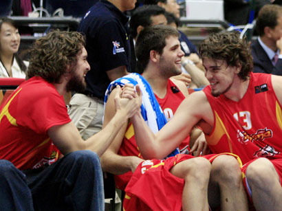 Spain's Paul Gasol (L) and his brother Marc (R) celebrate their victory over Greece as team mate Felipe Reyes watches during their final game at the world basketball championships in Saitama, Japan, September 3, 2006.