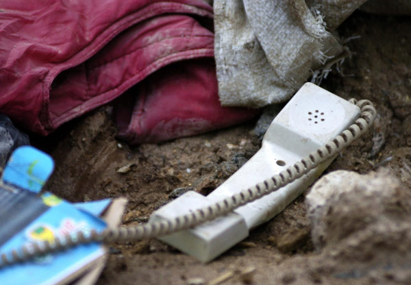 Personal items lie amid muddy ruins