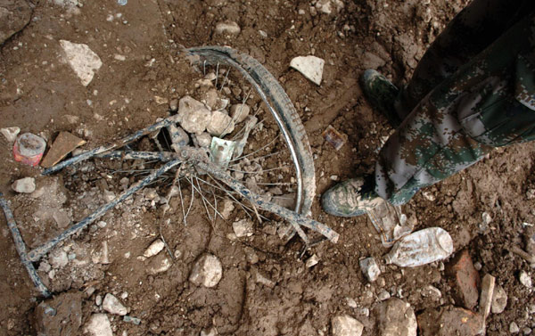 Personal items lie amid muddy ruins