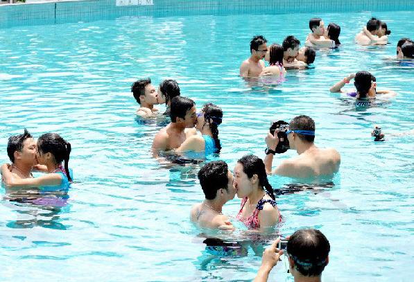 Couples prepare for an underwater kissing contest held in Guangzhou, Guangdong province on July 6, 2013. Underwater kissing contest a wet affair