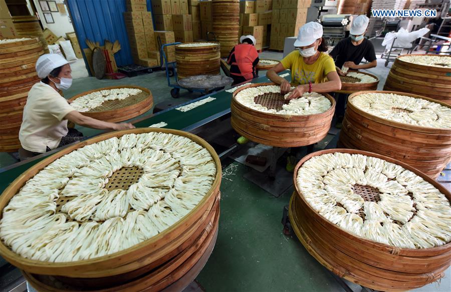 Workers make Kuanmiao noodles in SE China's Taiwan