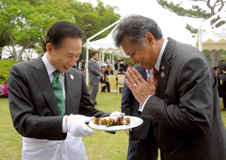 Lee Myung-bak delivers dish during lunchoen