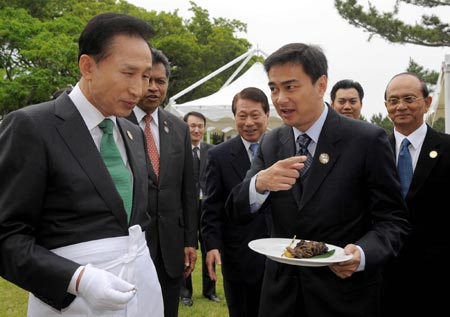 Lee Myung-bak delivers dish during lunchoen