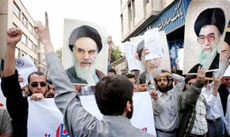 Iranian protesters chant anti-U.S. slogans as they hold pictures of Iran's late leader Ayatollah Ruhollah Khomeini (L) and Supreme Leader Ayatollah Ali Khamenei during a protest against negotiation with the U.S. in front of the Iran Supreme National Security Council's building in Tehran, Iran April 8, 2006.
