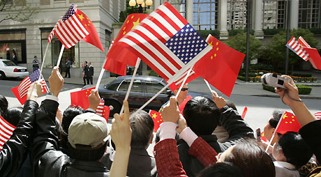 Members of the official welcoming committee wave flags as the motorcade bringing Chinese President Hu Jintao arrives at his hotel in Seattle April 18, 2006.