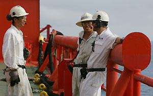 Norwegian and mainland Chinese workers chat on the deck of Bluewater's floating production, storage and offloading (FPSO) vessel Munin, which floats on the Lufeng oil field, 250 kilometers south-east of Hong Kong in the South China Sea, in 333 meters of water, May 23, 2006.