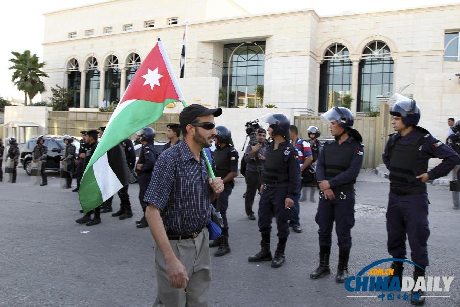 一男子肩扛约旦国旗经过埃及大使馆
