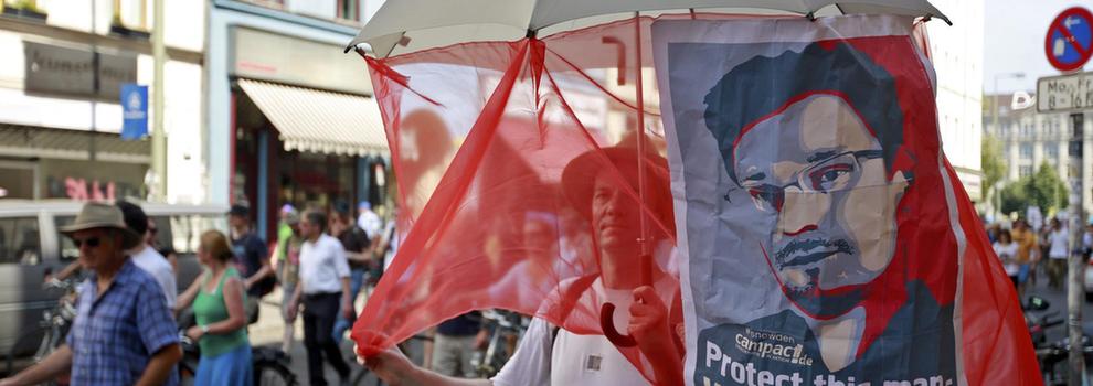 <P><SPAN>斯诺登支持者举着他的海报游行</SPAN></P>
