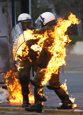 一名防暴警察因为被示威者投掷的燃烧弹击中