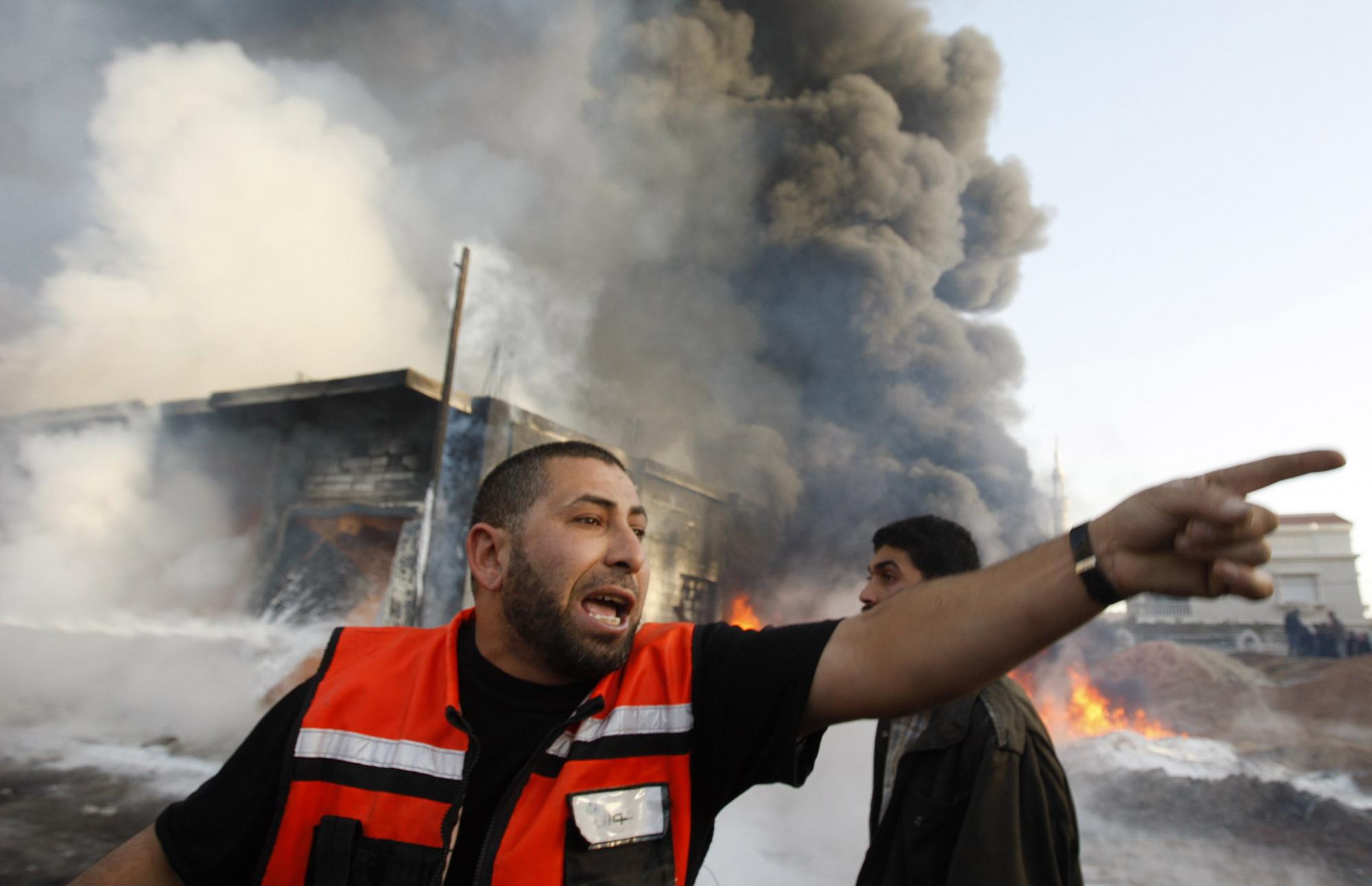 一名巴勒斯坦消防员在被以色列轰炸的大楼前; 以酝酿地面行动 哈马斯