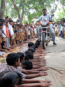 印度学校的特技表演:摩托车碾过学生的手