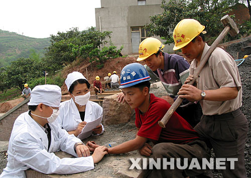  2003年5月9日，中铁二局巡回防疫小分队的医务人员在成都市龙泉驿区白工堰建设工地为施工人员检查身体。为预防非典传播，中铁二局医务人员深入各建设工地，为施工人员和驻地山村群众免费检查身体，宣传防疫知识。 新华社发 