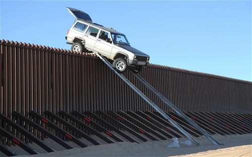 美墨边境走私者又出歪招 开车翻越隔离墙被卡墙头