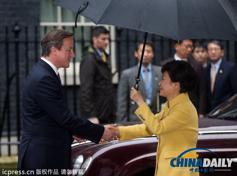 朴槿惠独自撑伞与卡梅伦雨中会面