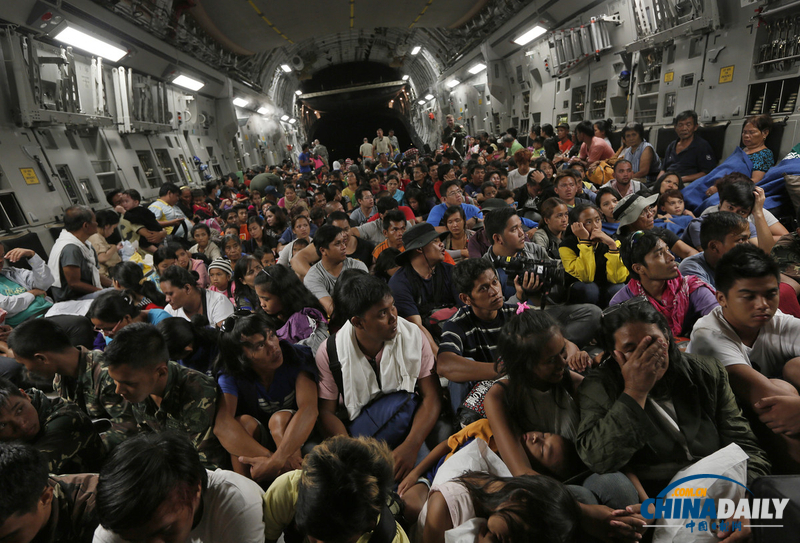 菲律宾台风难民乘美救援机抵达马尼拉 高举双