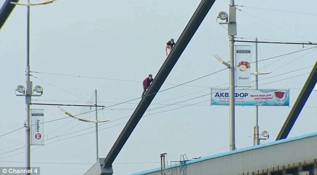 极限运动爱好者握住同伴手腕悬挂115米高空