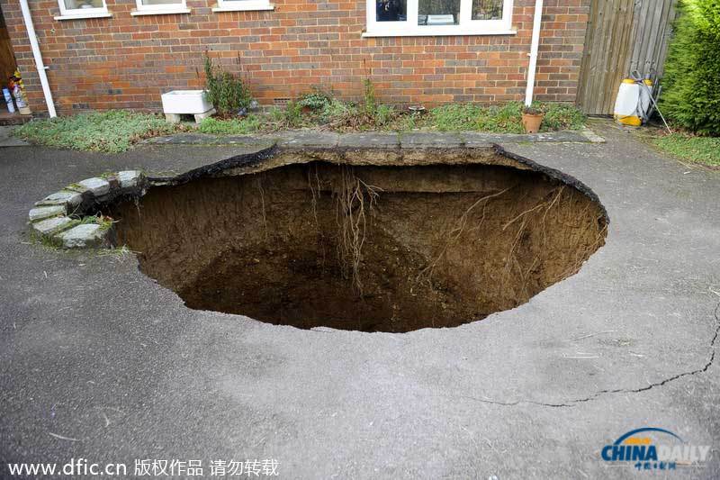 英国居民房屋前惊现大坑 汽车惨遭“吞噬”
