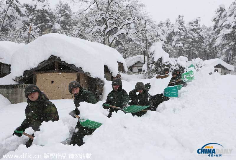 韩国暴雪持续5日 汽车被埋红绿灯遭积雪覆盖