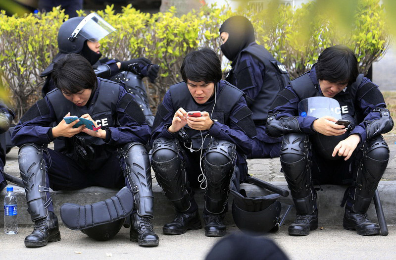 泰国稻农取消机场示威 防暴警察得闲玩手机[1