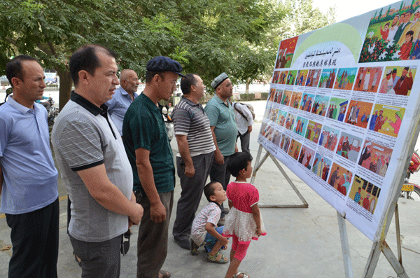 Local Villagers In Shache County Examine Illustrations Teaching Them How To Identify Extreme