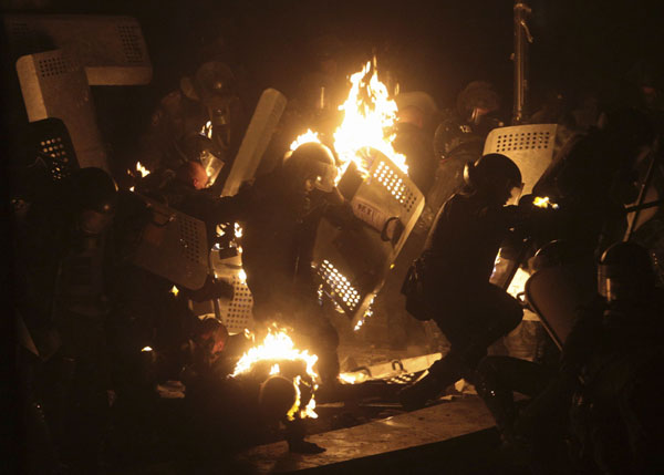 A protester points a handgun during a clash with police in central Kiev