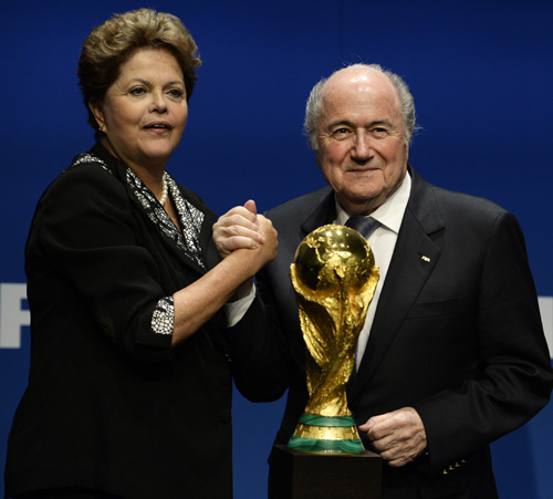 fifa president sepp blatter stands next to the world cup trophy as he