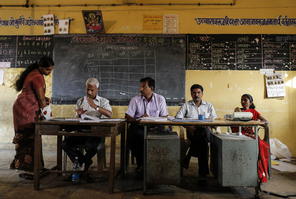 A Voter Is Helped At A Polling Station In Kamshet A