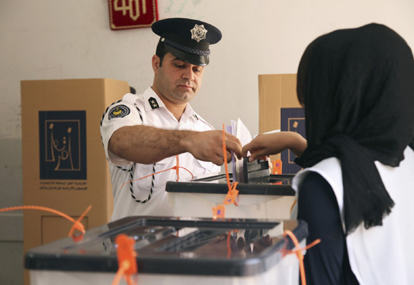 traffic policeman casts his vote into a ballot box during early 