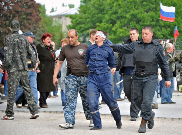 Pro Russian Militants Escort An Man Outside The Regional State Building In The Eastern Ukrainian