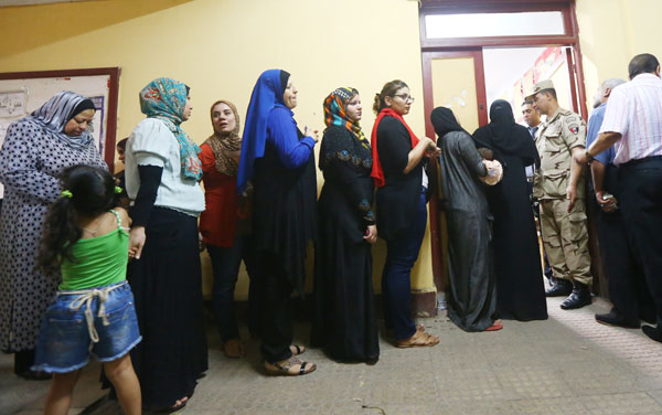 egyptians wait to cast their vote inside a polling station ...