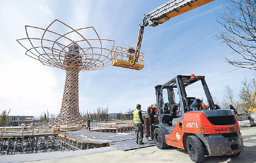 workers running behind schedule stand near the 37 meter tree of life 