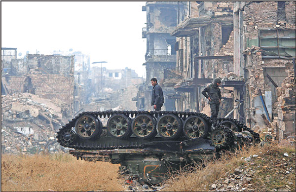 forces loyal to the syrian government stand atop a damaged