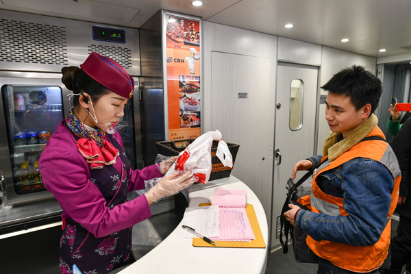 A Courier Delivers A Food Order For Passengers To An Attendent On A High Speed Train In