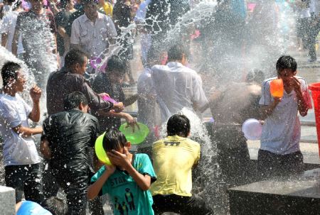 Young people spray water to each other during Double Seventh Festival