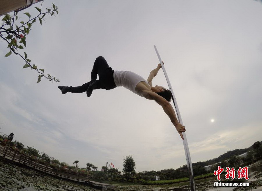 Male pole dancer shows strength and beauty