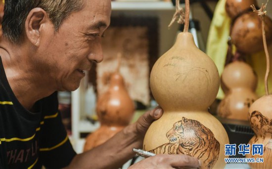 Jilin craftsman, 57, makes over 1,000 gourd pyrography works