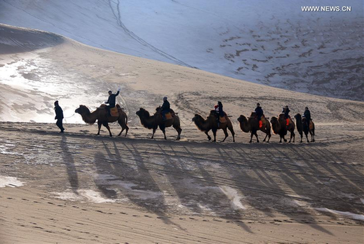 Tourists visit Mingsha Mountain in NW China's Dunhuang