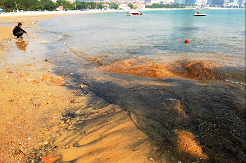 Black sand seen on beach of Qingdao