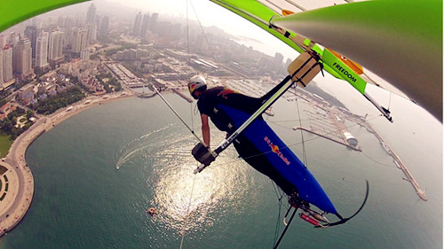 Hang gliding man flies over Jiaozhou Bay