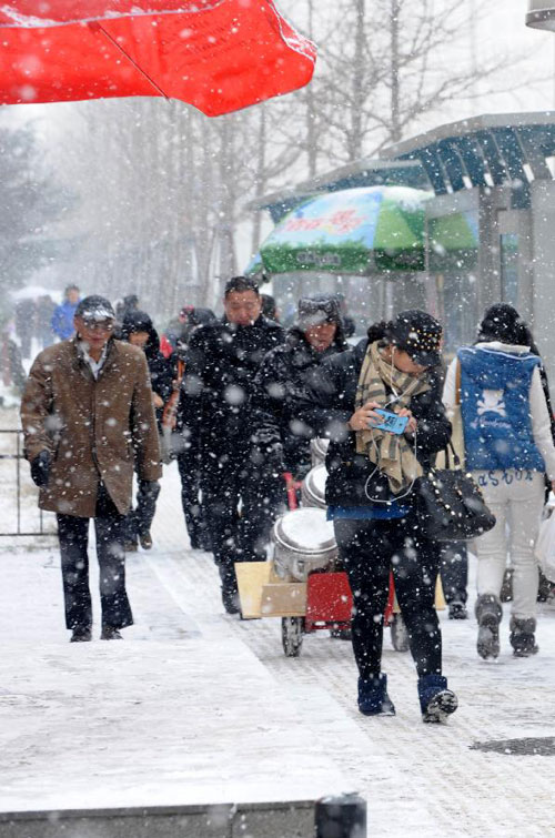 People walk in snow in Qingdao