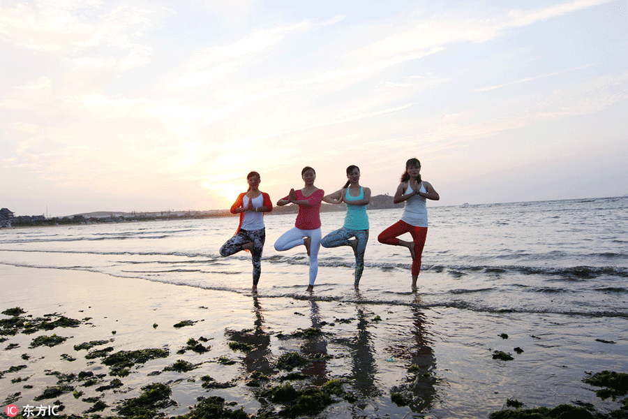 Fans practice yoga at seaside in E China