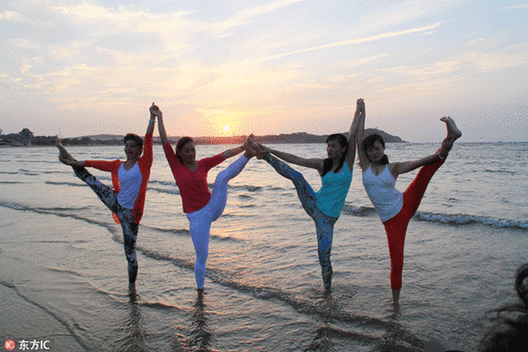 Fans practice yoga at seaside in E China