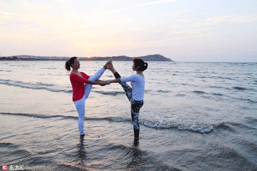 Fans practice yoga at seaside in E China