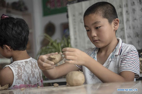 Pupils learn to make 'Qixia painted clay sculpture'