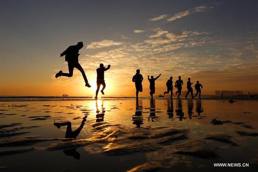 College students run on beach in Yantai