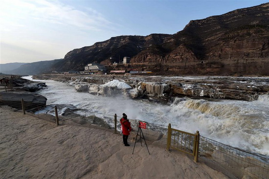 Silver thawing ice scenery of Hukou Waterfall in N China