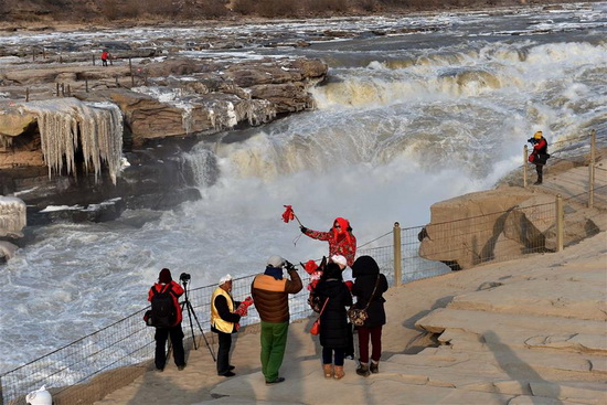 Silver thawing ice scenery of Hukou Waterfall in N China