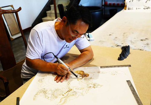 Shanxi artist expresses love for hometown in pyrographic art