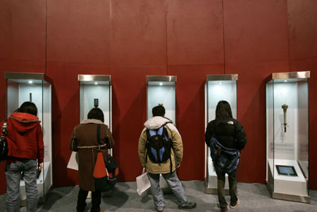 Visitors look at torches displayed at an exhibition on the history of Olympic Games in Hong Kong February 14, 2008. Hong Kong will hold the equestrian event of the Beijing 2008 Olympic Games in coming August.