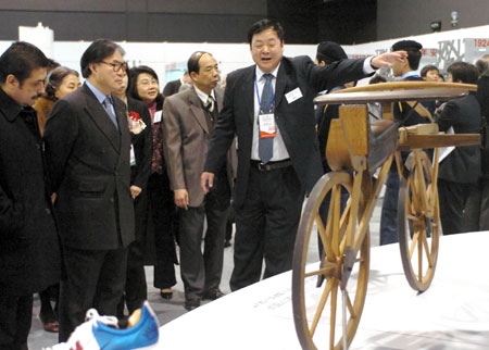 Visitors view a wooden bicycle make in 1800 at an exhibition on the history of Olympic Games in Hong Kong February 14, 2008. Hong Kong will hold the equestrian event of the Beijing 2008 Olympic Games in coming August. 